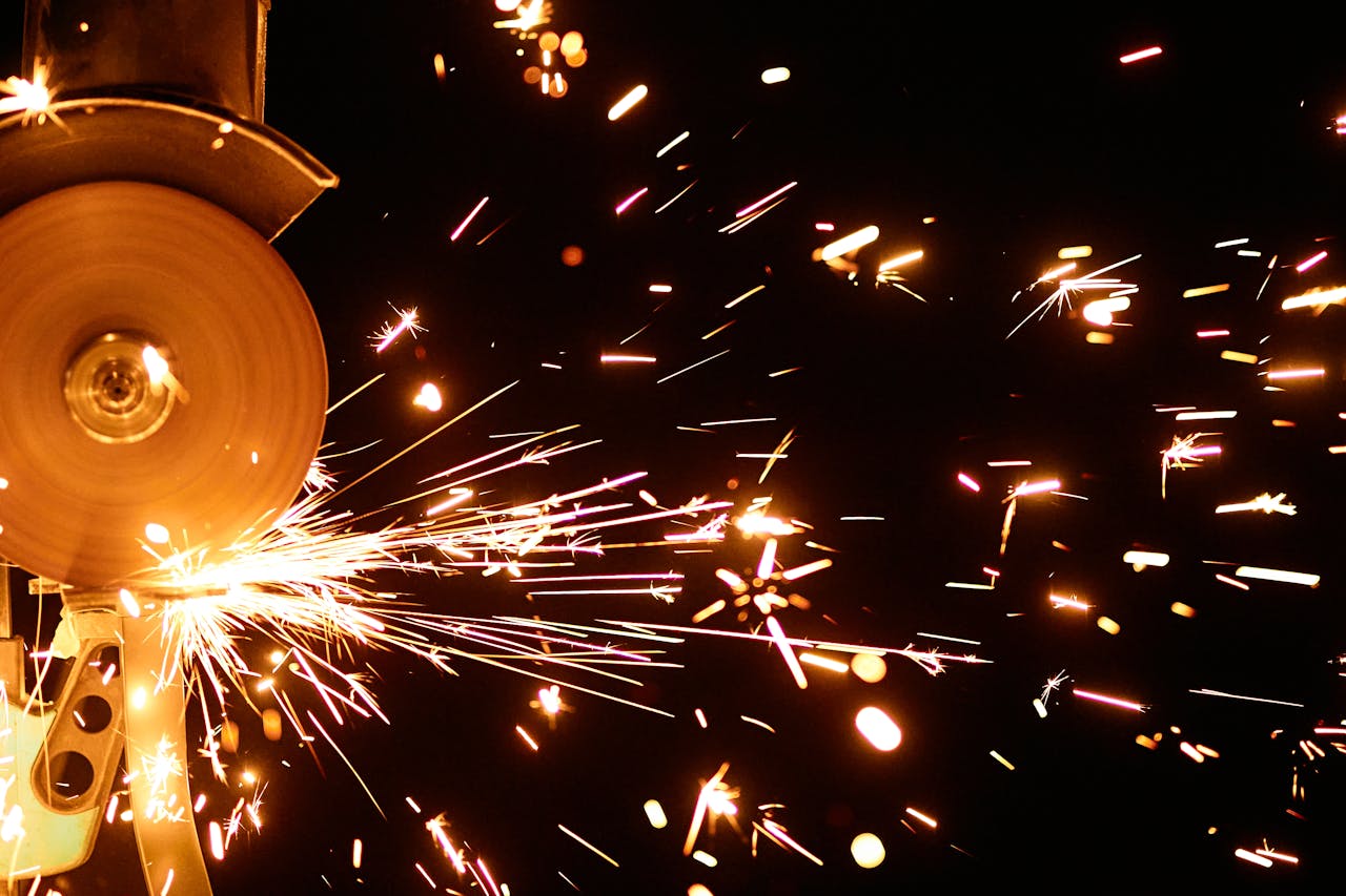 Close-up of sparks flying from an angle grinder against a black background. Perfect for industrial and technology themes.