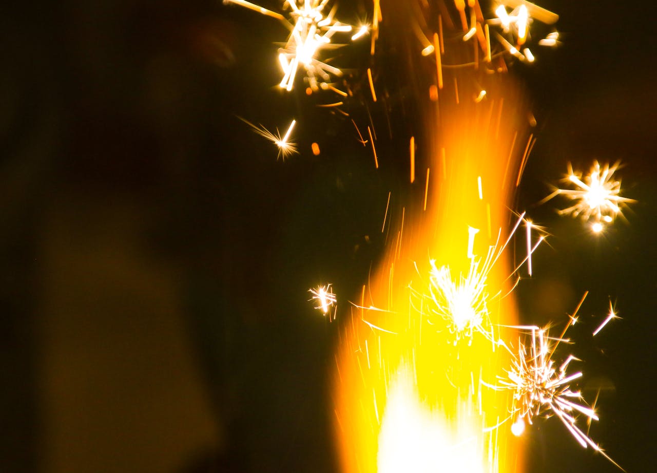 Captivating close-up of fireworks with bright sparks illuminating the dark night.